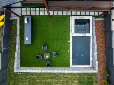 A backyard showcasing a grill, a pool for relaxation, and a fire pit for evening warmth.