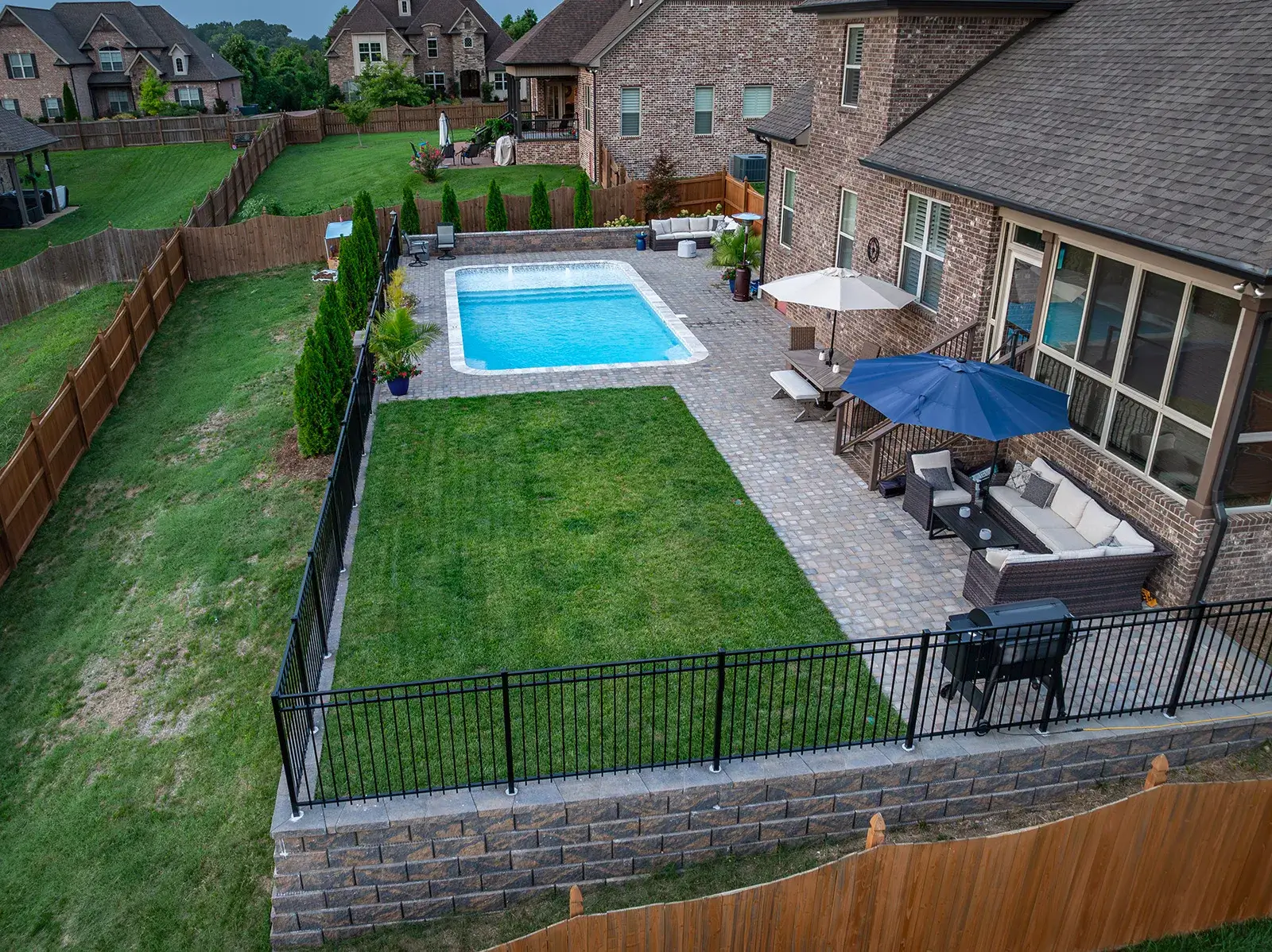 A spacious backyard with a swimming pool and a protective fence, creating a safe and inviting outdoor environment.