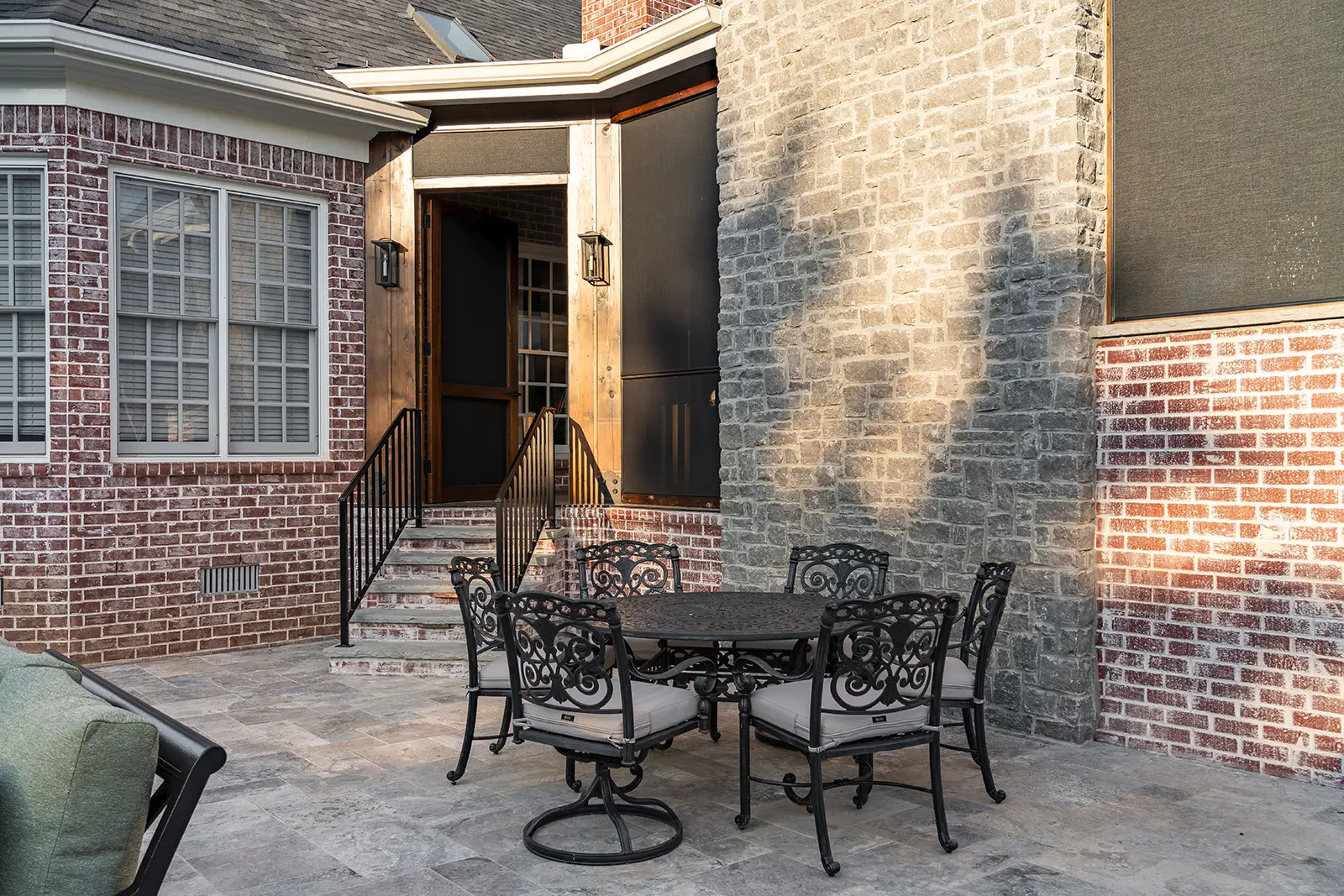 A brick home with a patio that includes a table and chairs for outdoor seating.