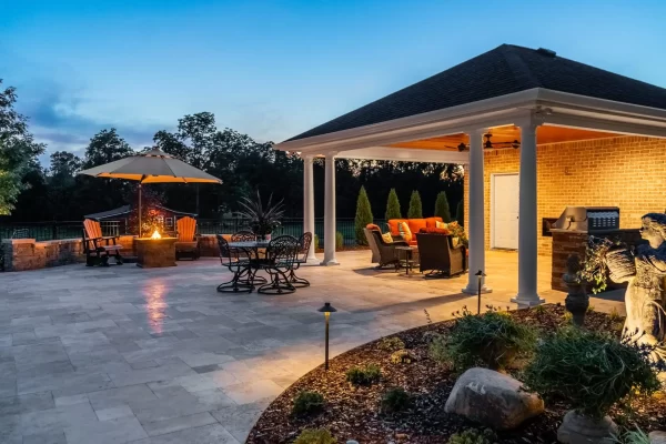 A gazebo and patio area illuminated by soft lights at dusk, creating a serene and inviting outdoor atmosphere.