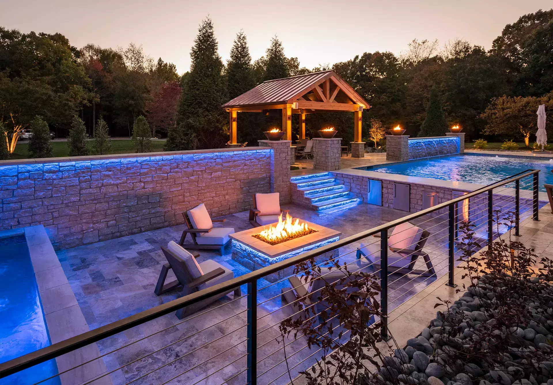 A stylish poolside setting showcasing a fire pit and plush lounge chairs for a perfect outdoor retreat.