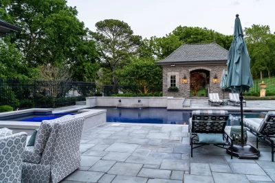 A serene pool surrounded by patio furniture and a gazebo, perfect for relaxation and outdoor gatherings.