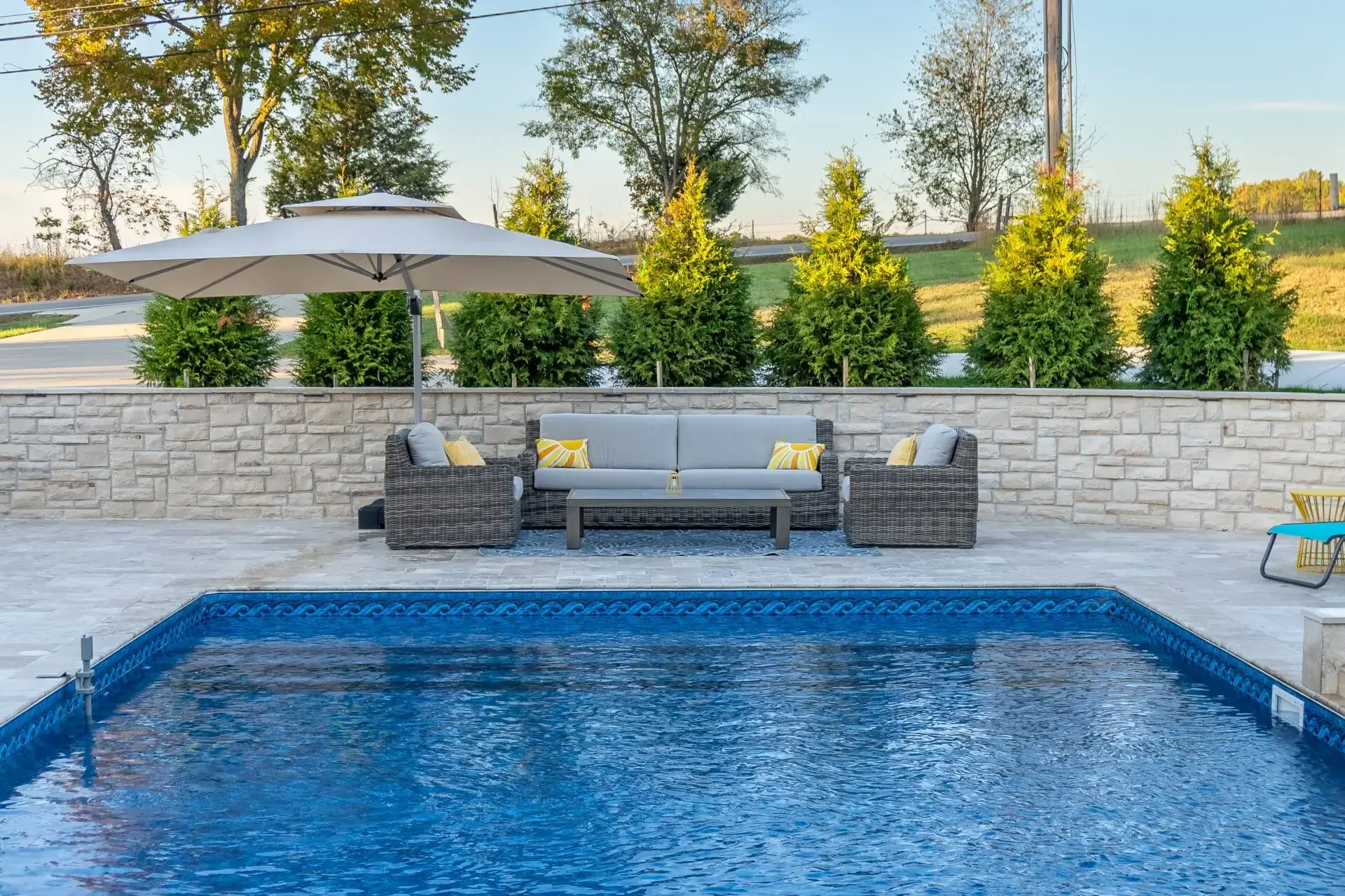An outdoor swimming pool with lush garden 
